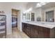 Bathroom with double sink vanity, large mirror, and access to walk-in closets at 10490 Palmadora St, Las Vegas, NV 89178
