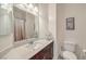 Cozy bathroom featuring a single sink vanity, toilet, and shower with curtain at 10490 Palmadora St, Las Vegas, NV 89178