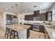 Modern kitchen featuring dark cabinets, granite countertops, stainless steel appliances, and pendant lighting at 10490 Palmadora St, Las Vegas, NV 89178