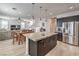 Open kitchen featuring dark cabinets, granite countertops, stainless steel appliances, and wood floors at 10490 Palmadora St, Las Vegas, NV 89178
