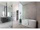 A modern bathroom features a soaking tub, glass shower, and elegant tile work at 10921 Rossa Peak Ave, Las Vegas, NV 89135