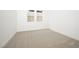 A bright, minimalist bedroom featuring neutral carpet, white walls, and natural light at 10921 Rossa Peak Ave, Las Vegas, NV 89135