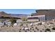 Community entrance with desert landscaping, stone walls, and views of the surrounding mountains at 10921 Rossa Peak Ave, Las Vegas, NV 89135