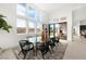 Bright dining room features large windows, sleek table, and neutral rug at 10921 Rossa Peak Ave, Las Vegas, NV 89135
