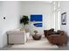 Relaxing living room with modern furniture, including a tufted sofa and brown leather armchairs at 10921 Rossa Peak Ave, Las Vegas, NV 89135