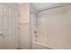 Bright bathroom featuring a white tiled shower-tub combination and a matching white door at 1115 Pearl Marble Ave, North Las Vegas, NV 89081