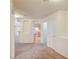 View from hallway through the arched doorway to the living and kitchen area with neutral carpet and white walls at 1115 Pearl Marble Ave, North Las Vegas, NV 89081