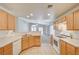 Cozy kitchen with light wood cabinetry, white appliances, and a view into the adjacent living room at 1115 Pearl Marble Ave, North Las Vegas, NV 89081