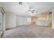 Open-concept living room with plush carpeting, sliding glass doors, and access to the adjacent kitchen at 1115 Pearl Marble Ave, North Las Vegas, NV 89081
