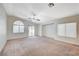 Spacious living room boasting plush carpeting, large windows, and a ceiling fan for comfortable living at 1115 Pearl Marble Ave, North Las Vegas, NV 89081