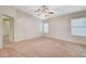 Large main bedroom with neutral carpet, ceiling fan, large windows, and white doors at 1115 Pearl Marble Ave, North Las Vegas, NV 89081