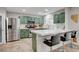 Modern kitchen features sage green cabinets, stainless steel appliances, quartz countertops, and stylish bar seating at 11157 Mezzana St, Las Vegas, NV 89141