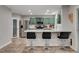 Modern kitchen features sage green cabinets, stainless steel appliances, quartz countertops, and stylish bar seating at 11157 Mezzana St, Las Vegas, NV 89141