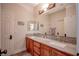 Spacious bathroom with dual sinks, granite countertops, wooden cabinets, and decorative mirror at 1125 Via Canale Dr, Henderson, NV 89011