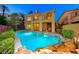 Inviting backyard pool with a rock waterfall feature and cozy seating area, perfect for relaxation and outdoor entertaining at 2 Cerchio Centrale, Henderson, NV 89011