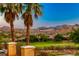 Scenic backyard view featuring palm trees, lush green golf course, homes, and picturesque mountains at 2 Cerchio Centrale, Henderson, NV 89011