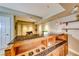 Close-up view of a bar area with a granite countertop, sink, and wooden cabinets for bottle storage at 2 Cerchio Centrale, Henderson, NV 89011