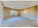 A spacious bedroom with neutral carpet, a large window overlooking a stone wall, and recessed lighting at 2 Cerchio Centrale, Henderson, NV 89011