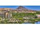 A picturesque view of a community with lush landscaping, a serene lake, and a striking mountain backdrop at 2 Cerchio Centrale, Henderson, NV 89011