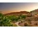 A home exterior on a landscaped lot near walking path, desert plants, and hillside at sunset at 2 Cerchio Centrale, Henderson, NV 89011