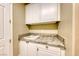 Functional laundry room with granite countertop, white cabinetry, and ample storage space at 2 Cerchio Centrale, Henderson, NV 89011