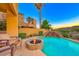 Backyard pool area with water feature, fire pit, seating and lush desert landscaping at 2 Cerchio Centrale, Henderson, NV 89011
