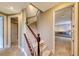 Hallway featuring a carpeted staircase with dark wood railing and white balusters leading up to the next floor at 2 Cerchio Centrale, Henderson, NV 89011