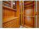 Well-organized walk-in closet with custom wood shelving, cabinets, drawers and glass doors at 2 Cerchio Centrale, Henderson, NV 89011
