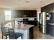 Modern kitchen featuring granite countertops, dark cabinetry, stainless steel appliances, and an open layout at 2204 Valdina St, Henderson, NV 89044