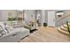 Open living area with wood-look floors, staircase, couch with throw pillows, and access to front door at 2250 Tedesca Dr, Henderson, NV 89052