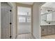 Hallway leading to a bathroom and a bedroom with carpet, ceiling fan, and natural light at 2603 Savannah Springs Ave, Henderson, NV 89052