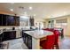 Well-lit kitchen with stainless steel appliances, dark cabinets, and a granite island at 2804 Colts Ave, North Las Vegas, NV 89032