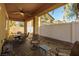 Covered patio area has brick flooring, seating, ceiling fan, and an adjacent fenced yard at 2804 Colts Ave, North Las Vegas, NV 89032