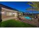 A backyard features a covered patio, pool, stone accents, and artificial grass for easy maintenance at 2820 Thunder Bay Ave, Henderson, NV 89052