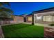 A backyard features a covered patio, block wall, desert landscaping, and artificial grass at 2820 Thunder Bay Ave, Henderson, NV 89052