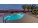 Outdoor oasis featuring a luminous pool surrounded by mature palm trees and stone landscaping at 2820 Thunder Bay Ave, Henderson, NV 89052