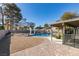 A spacious backyard featuring a covered patio, pool, brick pavers, and a rock garden, ideal for outdoor living at 3083 Paintedhills Ave, Las Vegas, NV 89120