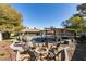 Inviting backyard with a pool, pergola, fire pit, and hanging pod chairs, perfect for outdoor entertaining at 3083 Paintedhills Ave, Las Vegas, NV 89120