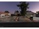 Charming home exterior featuring a well-manicured rock garden, illuminated walkways, and stylish curb appeal at twilight at 3083 Paintedhills Ave, Las Vegas, NV 89120