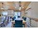 Open-concept kitchen and dining room with a large wooden table, island seating, and backyard access at 3083 Paintedhills Ave, Las Vegas, NV 89120