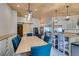 Well-lit eat-in kitchen with barstool seating at island, long wooden dining table, and stainless appliances at 3083 Paintedhills Ave, Las Vegas, NV 89120