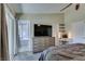 Bright primary bedroom featuring modern lighting, TV, and slider door at 3083 Paintedhills Ave, Las Vegas, NV 89120