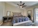 Spacious main bedroom featuring a cozy bed, ceiling fan, and natural light from glass door at 3083 Paintedhills Ave, Las Vegas, NV 89120