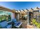 Relaxing outdoor patio featuring a pergola, brick pavers, fire pit table, and comfortable seating at 3083 Paintedhills Ave, Las Vegas, NV 89120