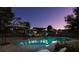 Backyard pool area with umbrellas and a pergola, ideal for relaxation and enjoying the evening ambiance at 3083 Paintedhills Ave, Las Vegas, NV 89120