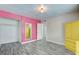 Bedroom with wood floors, closet and mirror, a yellow armoire, and a pink accent wall at 3247 Greenbriar Dr, Las Vegas, NV 89121