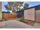 Private yard with a concrete patio, mature landscaping, and wooden perimeter fence at 3301 China Dr, Las Vegas, NV 89121
