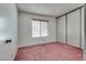 Bright bedroom with a window, neutral walls, carpet, and a closet with sliding doors at 3301 China Dr, Las Vegas, NV 89121