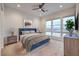 Serene bedroom features a blue bed, stylish decor, and expansive windows showcasing a scenic mountain view at 3346 Esker Ridge Ave, Henderson, NV 89044