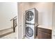 Practical laundry area with stacked washer and dryer, next to staircase at 3346 Esker Ridge Ave, Henderson, NV 89044